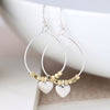 Worn silver teardrop earrings with golden beads and heart